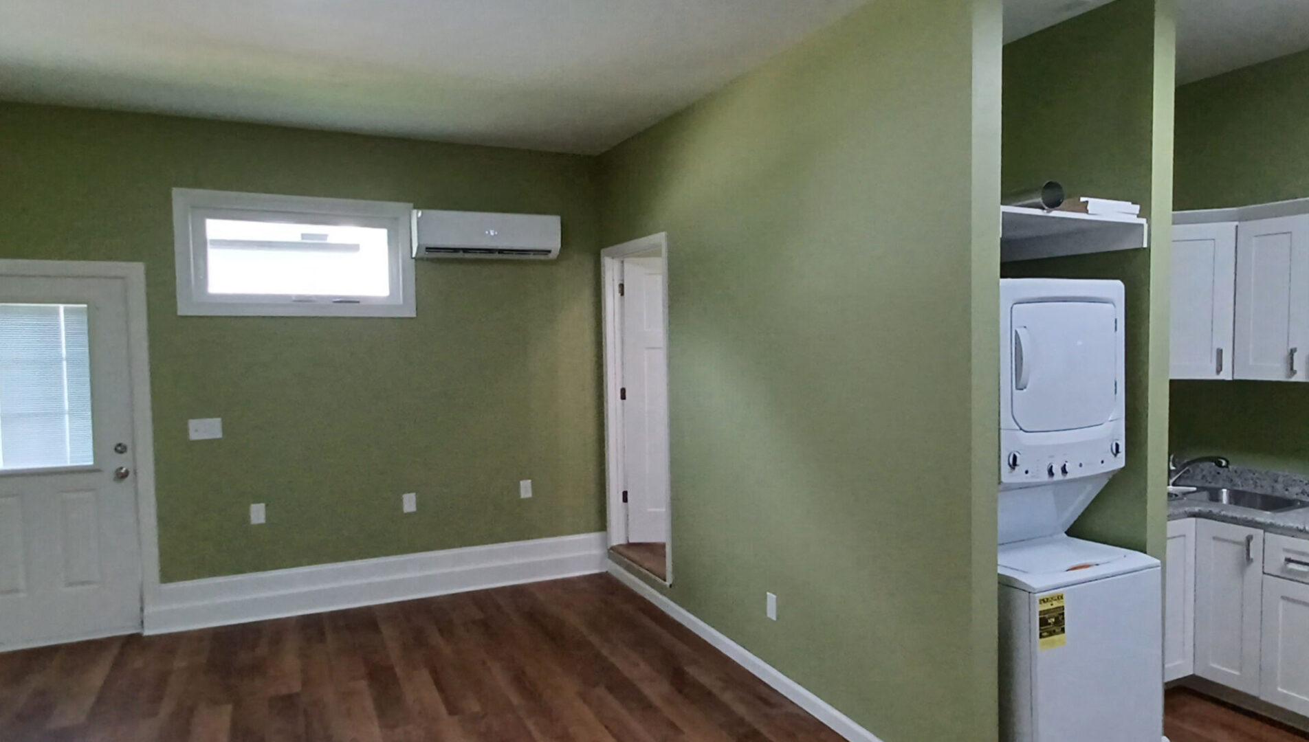 Compact laundry area in green-walled room